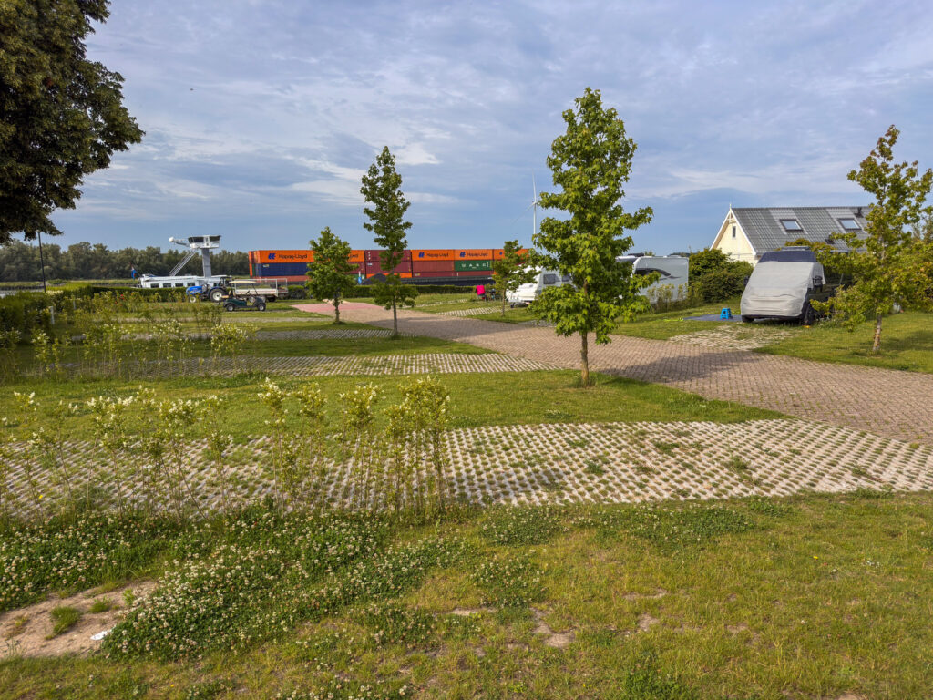 Recreatiepark de Oude Maas mit Blick auf de Oude Maas und einem Frachter der dort entlangschippert